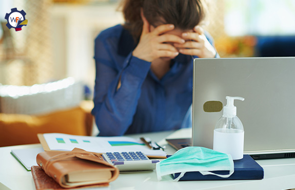 Empresaria en su Puesto de Trabajo Preocupada y con Manos en el Rostro