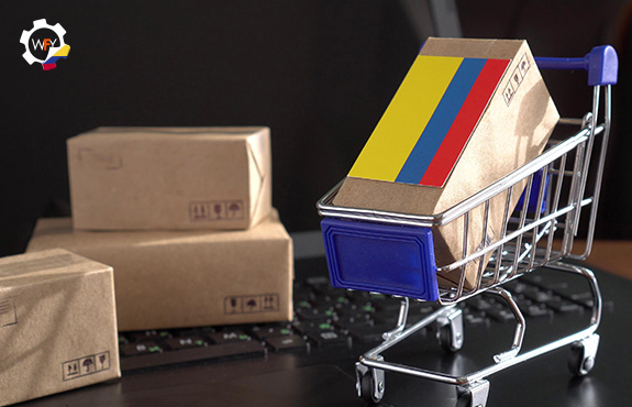 Carrito de Ecommerce con Caja y Bandera de Colombia Sobre Teclado de Laptop