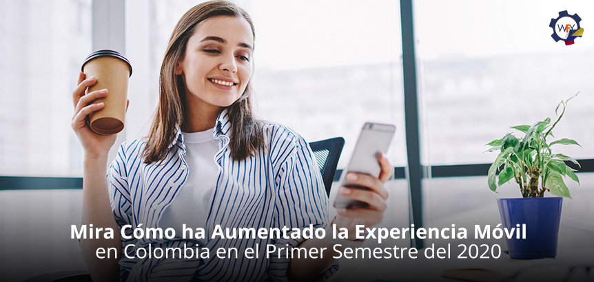 Joven Sonriente Mirando su Smartphone y Sosteniendo un Caf